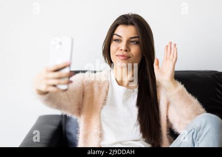 Glückliche Frau winkt Hand mit Smartphone-App genießen Online-virtuellen Chat Videoanruf mit Freunden im Fernchat virtuellen Meeting, aufzeichnen Geschichten Stockfoto