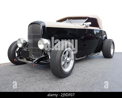 Ein Cabrio Hi-Boy Hot Rod Automobil, 1932 Ford Model B, 3 Fenster, deuce Coupé, Roadster. Isoliert auf weiß mit Straße, keine Logos. Stockfoto