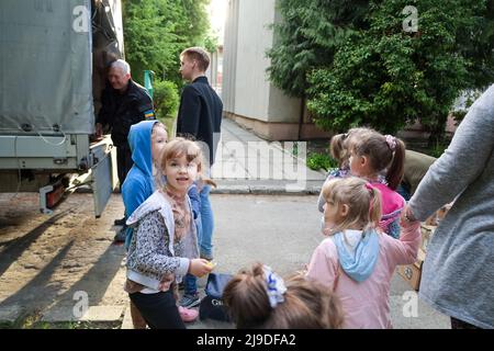 17. Mai 2022, Lemberg, Ukraine: Waisenkinder und Flüchtlingskinder in der Ukraine vermischen sich unter den wachsamen Augen der Waisenhausmitarbeiter, da Yurii Lomikovskyi, Organisator der Ukrainischen Studentenliga, Veteranen im Hilfskräfte David Foster aus Großbritannien unterstützt und am 16. Mai 2022 die benötigten Vorräte und Süßigkeiten für sie in ihrem Waisenhaus in Lemberg abgibt. Unter den Jungen und Mädchen, die vor der brutalen Invasion in Russland, und einige davon wegen, elterlos wurden, sind einige Flüchtlingskinder, die mit ihren Eltern auf dem Gelände wohnen, die vor kurzem aus vom Krieg zerrissenen Städten in der Ukraine geflohen sind. Besuchen Sie www.en.usl.org.u Stockfoto