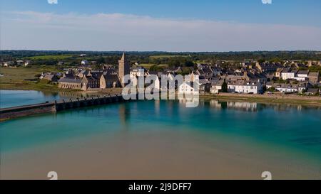 Blick auf die Kirche von Portbail von der Brücke mit einer Spiegelung der Kirche im Wasser Stockfoto