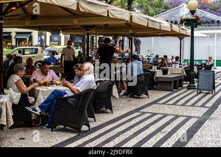 Menschen, die außerhalb des Ritz Restaurants, Avenida Arriaga, Funchal, Madeira essen. Stockfoto