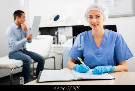 Kosmetikerin verschreibt dem Mann in der Klinik kosmetische Verfahren Stockfoto