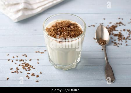 Einfache gesunde Frühstück oder Snack. Naturjoghurt mit gemahlenen Leinsamen in Gläsern auf hellblauem Hintergrund Stockfoto
