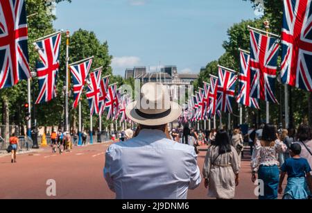 Tourist fotografiert die Union Jack-Flaggen, die von der Mall bis zum Buckingham Palace vor dem Platinum Jubilee der Königin gehangen wurden Stockfoto