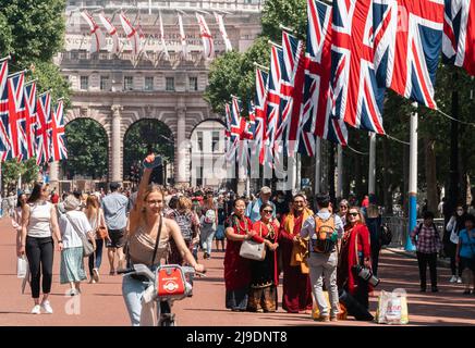 Tourist fotografiert die Union Jack-Flaggen, die von der Mall bis zum Buckingham Palace vor dem Platinum Jubilee der Königin gehangen wurden Stockfoto