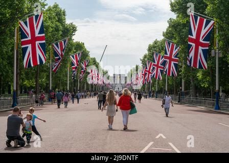 Tourist fotografiert die Union Jack-Flaggen, die von der Mall bis zum Buckingham Palace vor dem Platinum Jubilee der Königin gehangen wurden Stockfoto