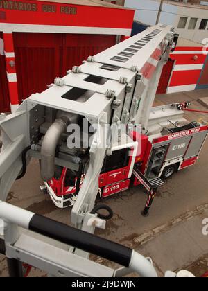 Ein Magirus Iveco 180E28 Feuerwehrwagen des General Corps of Volunteer Firefighters of Peru - CGBVP - verlängert seinen Teleskopkran Stockfoto