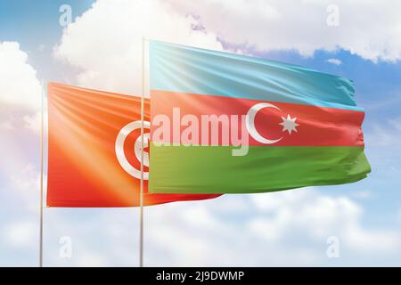 Sonniger blauer Himmel und Flaggen von aserbaidschan und tunesien Stockfoto