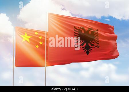 Sonniger blauer Himmel und Flaggen von albanien und china Stockfoto