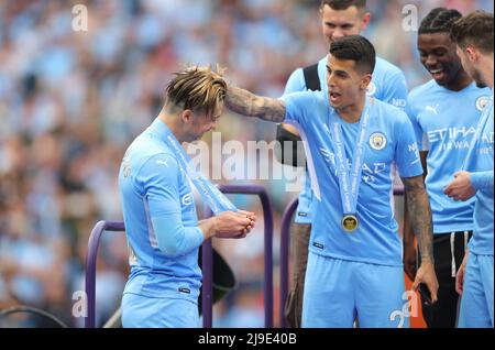 (220523) -- MANCHESTER, 23. Mai 2022 (Xinhua) -- Jack Grealish (L) und Joao Cancelo aus Manchester City feiern den Sieg in der Premier League, nachdem sie Aston Villa während ihres Spiels in der englischen Premier League am 22. Mai 2022 besiegt hatten. (XINHUA) NUR ZUR REDAKTIONELLEN VERWENDUNG. NICHT ZUM VERKAUF FÜR MARKETING- ODER WERBEKAMPAGNEN. KEINE VERWENDUNG MIT NICHT AUTORISIERTEN AUDIO-, VIDEO-, DATEN-, REGALLISTEN-, CLUB/LEAGUE-LOGOS ODER „LIVE“-DIENSTEN. ONLINE-IN-MATCH-NUTZUNG AUF 45 BILDER BESCHRÄNKT, KEINE VIDEOEMULATION. KEINE VERWENDUNG BEI WETTEN, SPIELEN ODER VERÖFFENTLICHUNGEN EINZELNER CLUBS/VEREINE/VEREINE/SPIELER. Stockfoto