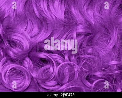 Lila gefärbtes Haar mit lockigen Wellen Textur Hintergrund Stockfoto