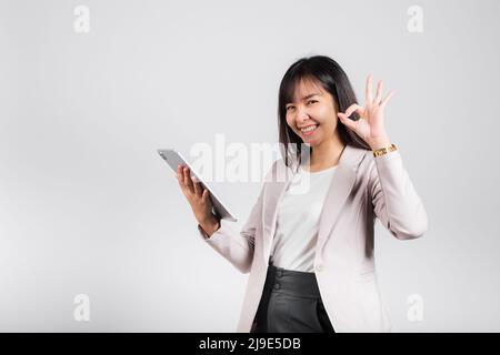 Porträt der asiatischen schönen jungen Frau lächelnd mit Tablet-Computer, Happy Lifestyle weibliche Teenager halten digitale Tablet-pc und zeigen OK Zeichen für akzeptieren, Stockfoto