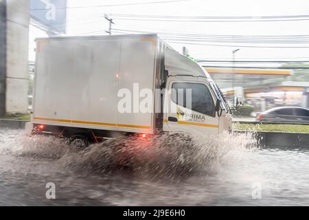 SAMUT PRAKAN, THAILAND, MAI 08 2022, fährt der LKW in eine große Pfütze auf der Straße und spritzt Wasser herum Stockfoto