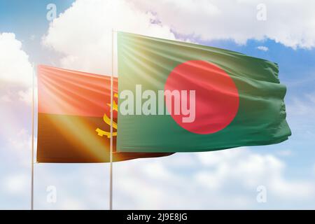 Sonniger blauer Himmel und Flaggen von bangladesch und angola Stockfoto