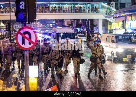 Polizeibeamte in Bereitschaftskleidung, die ihre Fahrzeuge mit Schilden, Schlagstöcken und Tränengaskanistern aussteigen, bereit, prodemokratische Demonstranten von den nahegelegenen Straßen zu entfernen. Prodemokratische Proteste brachen aus und eskalierten zu städtischen Konflikten, als sich die Hongkonger Regierung unter der Herrschaft Chinas weigerte, ein umstrittenes Auslieferungsgesetz zurückzuziehen und Polizeibrutalität gegen anfänglich friedliche Demonstranten duldete. Stockfoto