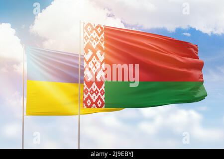 Sonniger blauer Himmel und Flaggen von weißrussland und der ukraine Stockfoto