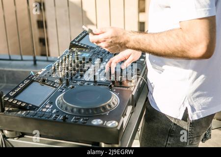 Die Hände des DJs mischen Musik auf dem Mixer aus nächster Nähe Stockfoto