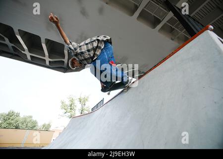 Teenage Boy Reiten Skateboard und machen Tricks in der Luft im Skatepark im Freien Stockfoto