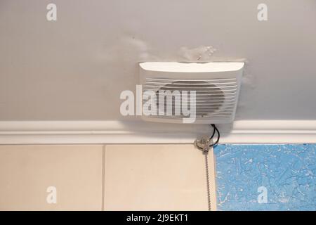 Elektrische Haube an der Decke im Bad in der Wohnung, Lüftungsloch im Bad an der Decke Stockfoto