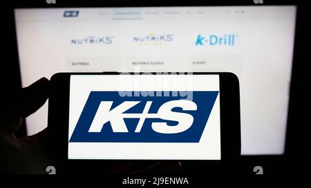 Person, die Smartphone mit Logo des deutschen Bergbauunternehmens KS AG (K plus S) auf dem Bildschirm vor der Website hält. Konzentrieren Sie sich auf die Telefonanzeige. Stockfoto