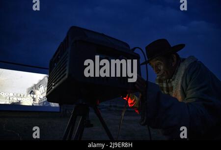 (220523) -- DAMXUNG, 23. Mai 2022 (Xinhua) -- Lodro überprüft und schießt den digitalen Filmprojektor im Dorf Barling, Landkreis Damxung in Lhasa, südwestlich der Autonomen Region Tibet, am 20. Mai 2022. Lodro lebt in Damxung County in Lhasa und ist ein ländlicher Vorführer von gemeinnützigen Open-Air-Kinos. Seit 1985 bereist Lodro fast zweihundert Dörfer auf den Grasländern Nordtibets. Für das Publikum in abgelegenen Gebieten wiederholt Lodro immer wieder Filmvorführungen, indem er die Leinwand und die Stereoanlage einstellt, den Generator und den Projektor überprüft und Fehlerbehebung vornimmt, Stockfoto