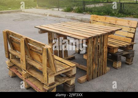 Palette Gartenmöbel. Rustikaler Holztisch und Bänke mit Paletten Stockfoto