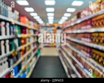 Abstrakt verschwommenes Lebensmittelgeschäft Gang mit bunten Produkten auf Regalen als Hintergrund. Konzept Verkauf Freigabe im Supermarkt. Stockfoto