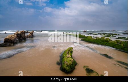 Eine lange Sicht auf die Felsformationen von Flysch bei Ebbe am Strand von Barrika in der Nähe von Bilbao Stockfoto