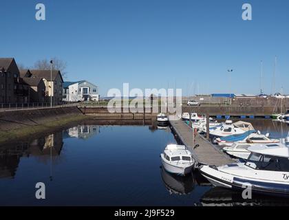 Blick über die Boote im Hafen von Nairn an einem sonnigen, wolkenlosen Tag mit dem schneebedeckten Berg Ben Wyvis im Hintergrund. Stockfoto