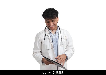 Junger peruanischer Arzt lächelt und schaut schüchtern nach unten, isoliert. Stockfoto