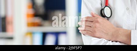Eine Ärztin in Uniform faltete ihre Arme über ihre Brust Stockfoto