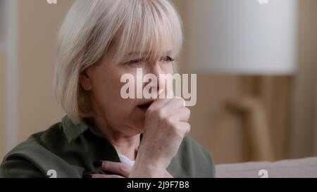 Portrait alte Frau Husten zu Hause. Nahaufnahme Unwohlsein kaukasische alternde reife Dame hustet mit Schmerzen in Brustkoronavirus-Symptomen. Großmutter leidet Stockfoto