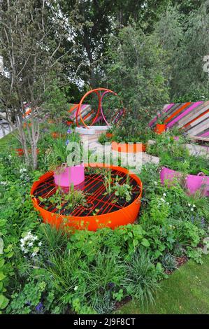 London, Großbritannien. 23.. Mai 2022. Der St Mungo’s Putting Down Roots Garden, einer der schönen Schaugärten, die auf der Royal Horticultural Society Chelsea Flower Show 2022 ausgestellt wurden, die heute auf dem Gelände des Royal Hospital Chelsea in Chelsea, London, Großbritannien, am 23. Mai 2022 eröffnet wurde. Dieser städtische Taschenpark verkörpert das Ethos des „Putting Down Roots“-Programms von St. Mungo, das Menschen geholfen hat, sich von der Obdachlosigkeit zu erholen, Selbstvertrauen zu gewinnen, ihre Fähigkeiten zu erweitern und ihr Leben durch Gartenarbeit wieder aufzubauen. Kredit: Michael Preston/Alamy Live Nachrichten Stockfoto