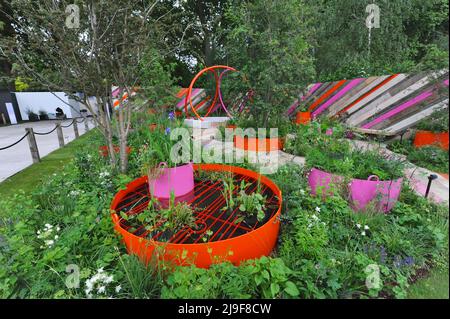 London, Großbritannien. 23.. Mai 2022. Der St Mungo’s Putting Down Roots Garden, einer der schönen Schaugärten, die auf der Royal Horticultural Society Chelsea Flower Show 2022 ausgestellt wurden, die heute auf dem Gelände des Royal Hospital Chelsea in Chelsea, London, Großbritannien, am 23. Mai 2022 eröffnet wurde. Dieser städtische Taschenpark verkörpert das Ethos des „Putting Down Roots“-Programms von St. Mungo, das Menschen geholfen hat, sich von der Obdachlosigkeit zu erholen, Selbstvertrauen zu gewinnen, ihre Fähigkeiten zu erweitern und ihr Leben durch Gartenarbeit wieder aufzubauen. Kredit: Michael Preston/Alamy Live Nachrichten Stockfoto