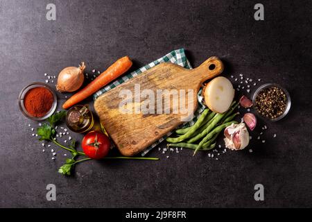 Sortiment an Gemüse, Kräutern und Gewürzen auf schwarzem Hintergrund Stockfoto