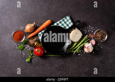 Sortiment an Gemüse, Kräutern und Gewürzen auf schwarzem Hintergrund Stockfoto