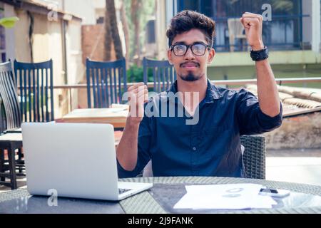 Indische asiatische College-Student Studium Freiberufler arbeiten mit einem Laptop auf dem Strand Sommer Café .Freelance und Remote work.Businessman auf der Veranda Stockfoto