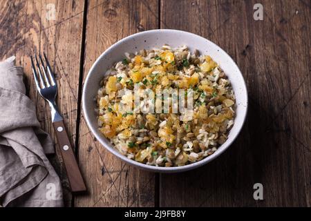 Traditionelles nahöstliches Gericht, Mujadara aus Linsen, Reis und gebratenen Zwiebeln auf Holztisch, Draufsicht, selektiver Fokus Stockfoto