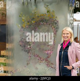 Royal Hospital, Chelsea, London, Großbritannien. 23 Mai 2022. Die RHS Chelsea Flower Show öffnet für die Presse zurück in seinem normalen Early Summer Slot läuft vom 24-28. Mai. Bild: Anneka Reis posiert mit einem Blumenportrait der Königin auf dem Veevers Carter Natural Perspectives Show Garden, der das Platin-Jubiläum feiert. Quelle: Malcolm Park/Alamy Live News. Stockfoto