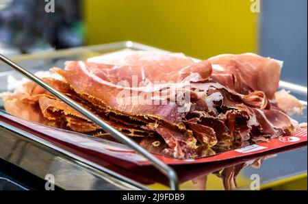 Iberischer Schinken, der mit Mais gefüttert wird, auf einer Waage. Trocken ausgehärtete Schinkenscheiben. Jamon iberico de bellota Stockfoto