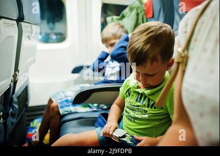 Zwei Jungen im kommerziellen Jet-Flugzeug fliegen im Urlaub. Stockfoto