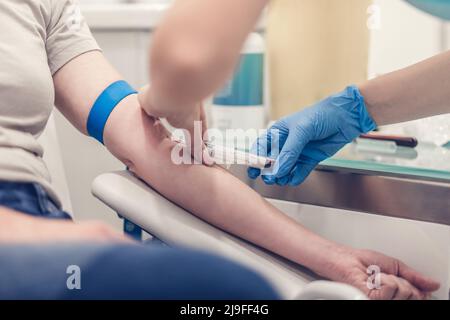 Nahaufnahme eines Arztes, der die Blutprobe aus dem Arm des Patienten im Krankenhaus für medizinische Tests entnehmen kann. Stockfoto