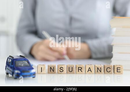 Der Vertriebsmitarbeiter füllt die Vertragsdokumente für die Kfz-Versicherung aus Stockfoto