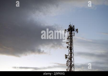 Telekommunikationsturm, 4G und 5G Funknetz Telekommunikationsausrüstung mit Funkmodulen und intelligenten Antennen am Abend auf Wolkenhimmel Hintergrund Stockfoto