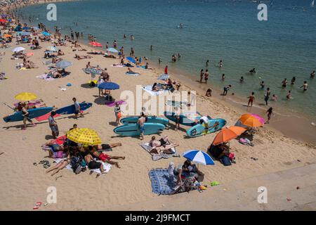 Barcelona, Spanien. 22.. Mai 2022. Eine Vielzahl von Badegäste werden am Strand von La Nova Icària auf der Suche nach Erfrischungen gesehen. Barcelona erreichte im Mai einen historischen Temperaturrekord. Die Thermometer berührten 30 Grad Celsius, was Anwohner und Touristen dazu ermutigte, sich vor der Sonne zu schützen oder sich zum Abkühlen an den Strand zu begeben. Kredit: SOPA Images Limited/Alamy Live Nachrichten Stockfoto