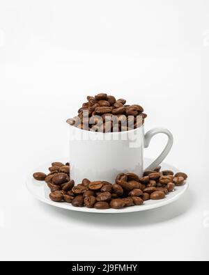 Perfekte kleine weiße Kaffeetasse mit gerösteten Kaffeebohnen auf weißem Hintergrund Stockfoto