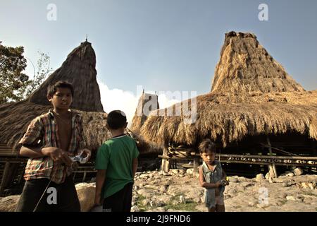 Kinderporträt vor traditionellen Häusern im traditionellen Dorf Praijing in Tebara, Waikabubak, West Sumba, Ost-Nusa Tenggara, Indonesien. Stockfoto