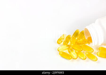 Hellgelbe ovale Pillen mit Fischöl (Omega-3 Vitamin) in der medizinischen Flasche auf weißem Hintergrund mit Kopierraum. Stockfoto