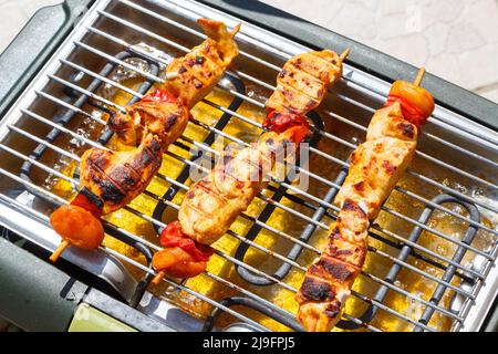 Marinierte Hähnchenbroschette auf elektrischem Grill Stockfoto