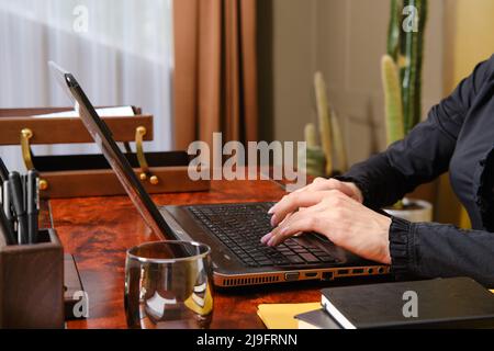 Nicht erkennbare Frau, die auf der Tastatur des Laptops tippt Stockfoto